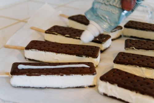 Adding icing to create Football Ice Cream Sandwiches 