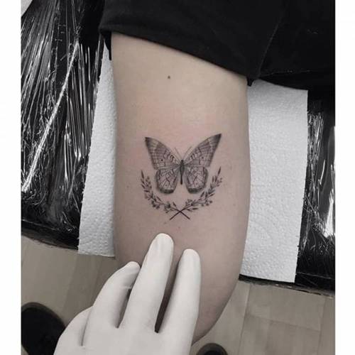 Fine line butterfly tattoo on the wrist.