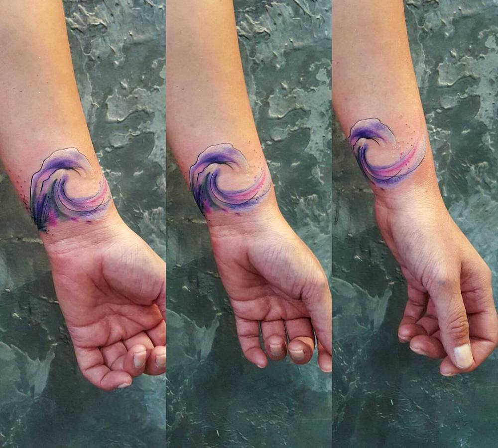 watercolor style wave tattoo on the left wrist watercolor style wave tattoo on the left wrist