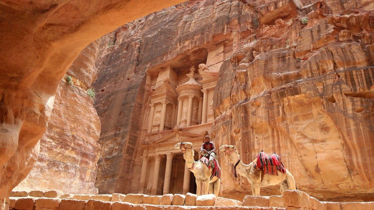PETRA. Un beduino jordano montado en un camello aparece frente del edificio del Tesoro en la antigua ciudad de Petra en Jordania el 9 de mayo de 2016. Establecido como la capital de los nabateos, la ciudad rosa de roca es el sitio turístico más...