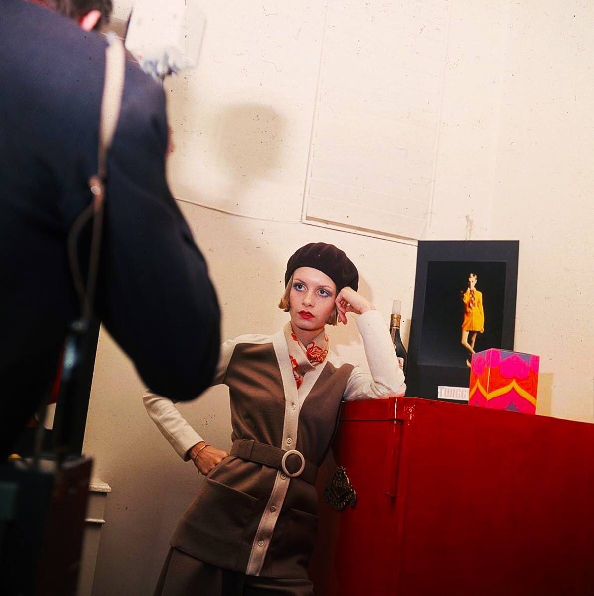 Twiggy, (Lesley Hornby), being photographed wearing a beret, matching cardigan and scarf in 1967