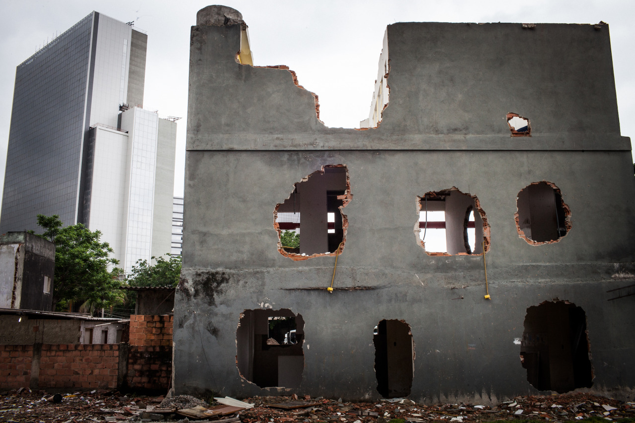 Destruida residencia en Vila Autódromo con una construcción olímpica en el fondo. Por Kim Badawi