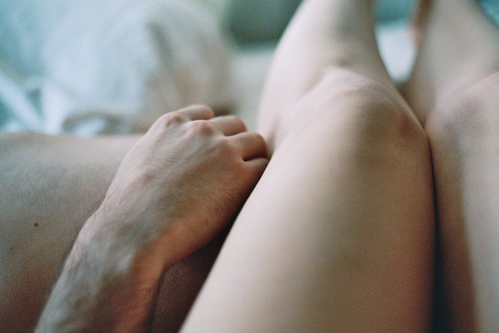Экзотичная женщина раздвигает ножки лежа в кровати и гладит пальцами вагину 