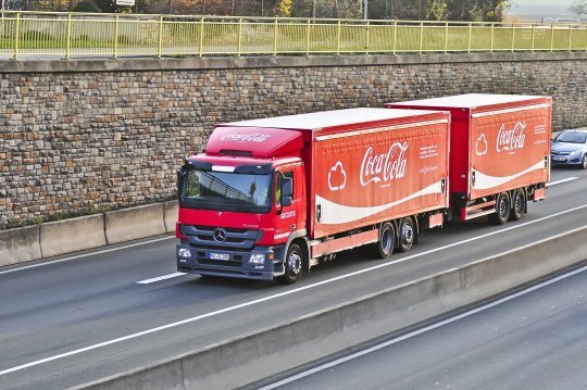 Caminhão vermelho com dois reboques em rodovia brasileira