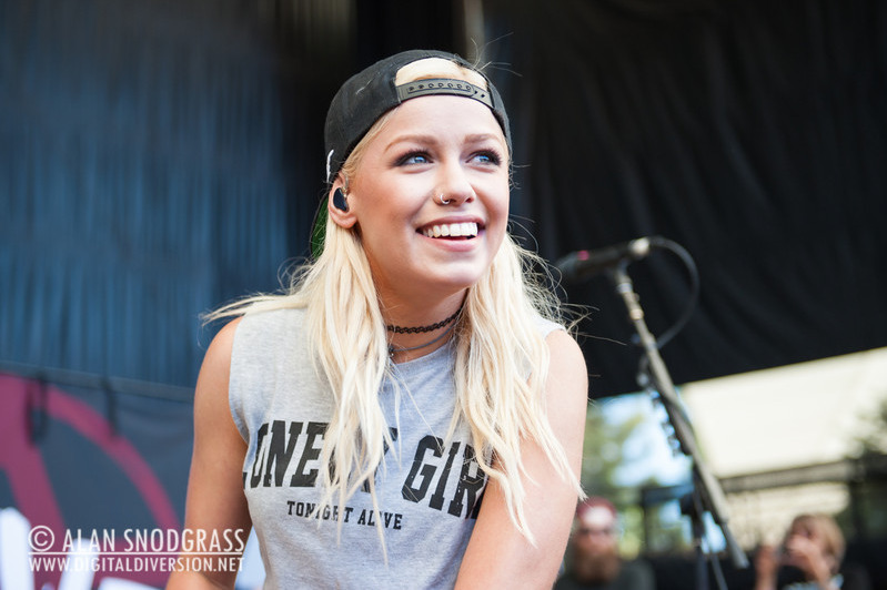 Jenna McDougall onstage, grinning widely in the sunlight