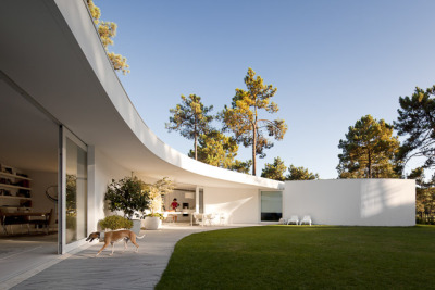 ombuarchitecture:<br /><br />House in Aroeira<br />Due to the absence of fences, the hexagonal shape of the plot is not clear and the ground blends with the surrounding pinewoods. The house occupies the maximal area of construction, concentric to the six-sided plot. Disposed round a courtyard to which every space converges, its peculiar form finds a precise boundary in the outline of the canopy. Service areas provide geometry and stability to the main spaces.<br />By Aires Mateus<br />Photos by FG+SG