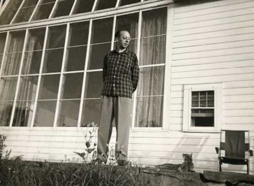 composersdoingnormalshit:Aaron Copland looking at his cat in the...