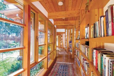 Hall of books in this oval-shaped timber-framed home located on Sidney Island, British Columbia. [1500 × 996]