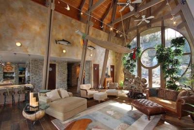 Large living area features high ceilings and a unique round window to bring in the light in this home on Lake Okanagan in British Columbia, Canada. [800 × 534]