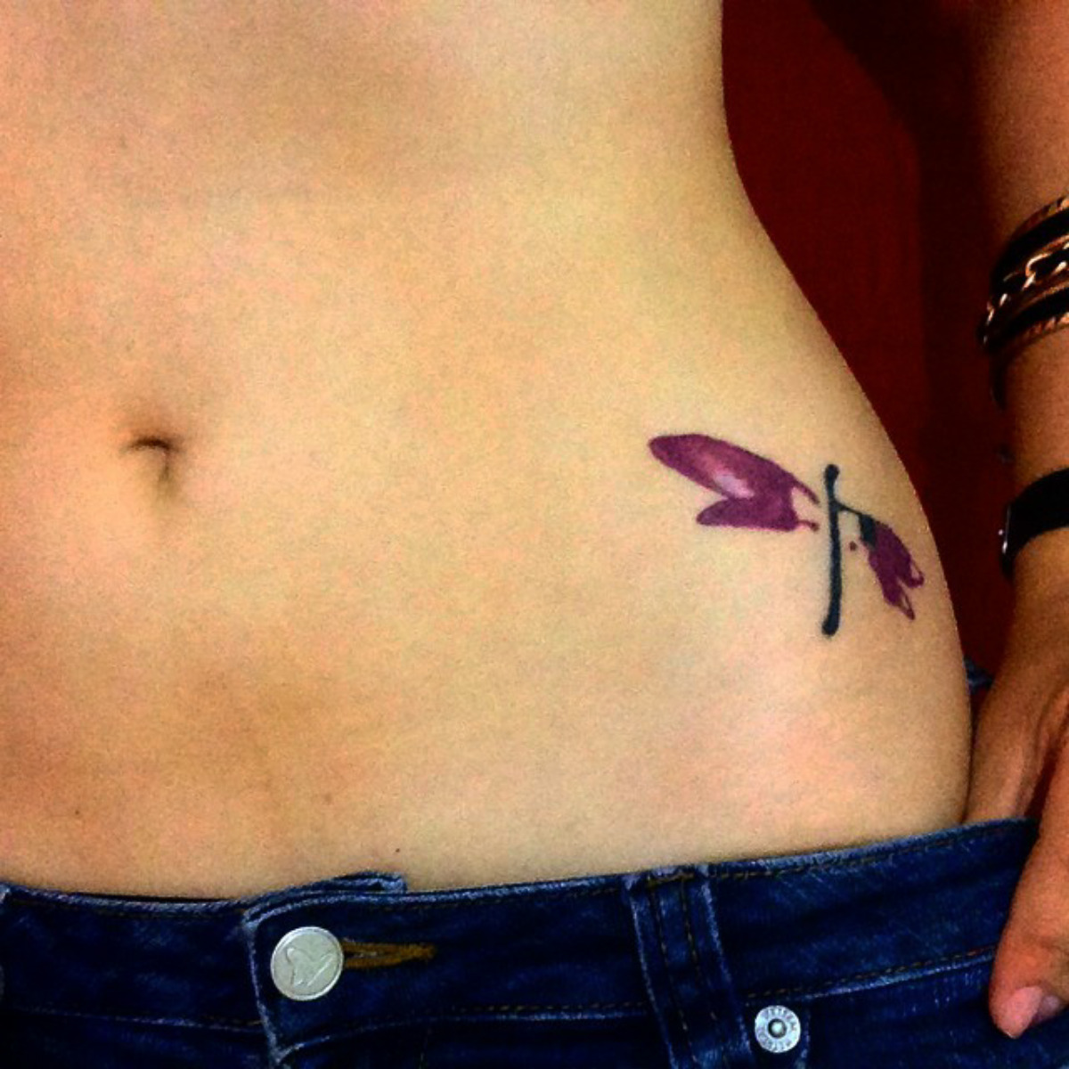 Little pelvis tattoo of a dragonfly on Gaby. 