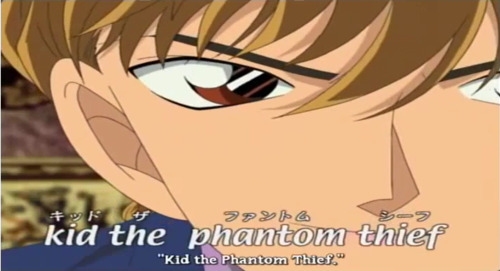 A picture of the character Hakuba Saguru from Magic Kaito, a teenage boy with tea-blond hair and brown eyes. The image is a subtitled screenshot, and the subtitles include three variations of "KID the Phantom Thief"--twice in English, and once in Japanese katakana.
