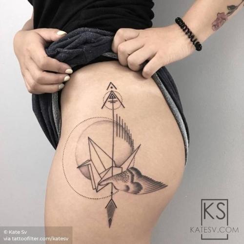 Geometric arrow tattoo on the right thigh.