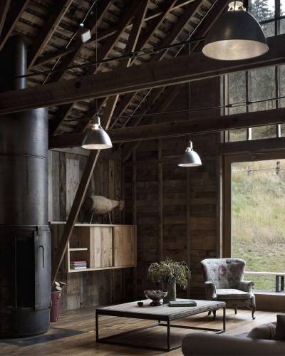 Sitting area in a converted a turn-of-the-century working barn features a large window to bring in extra light in this home in the Eastern Cascades, Washington. [1080 × 1350]