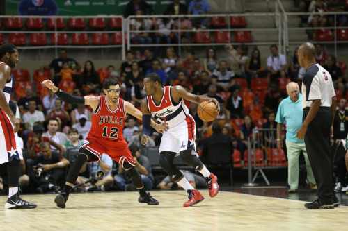 John Wall #2 of the Washington Wizards drives against Kirk Hinrich #12 of the Chicago Bulls during the game as part of 2013 Global Games …