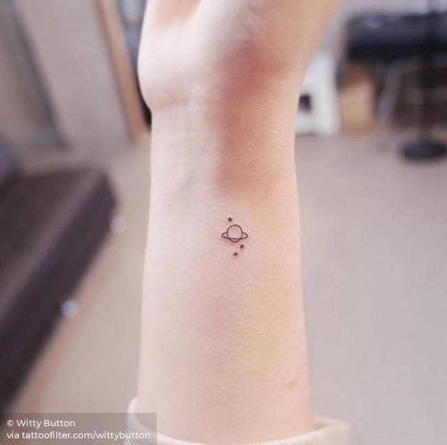 Minimalist Saturn tattoo on the bicep