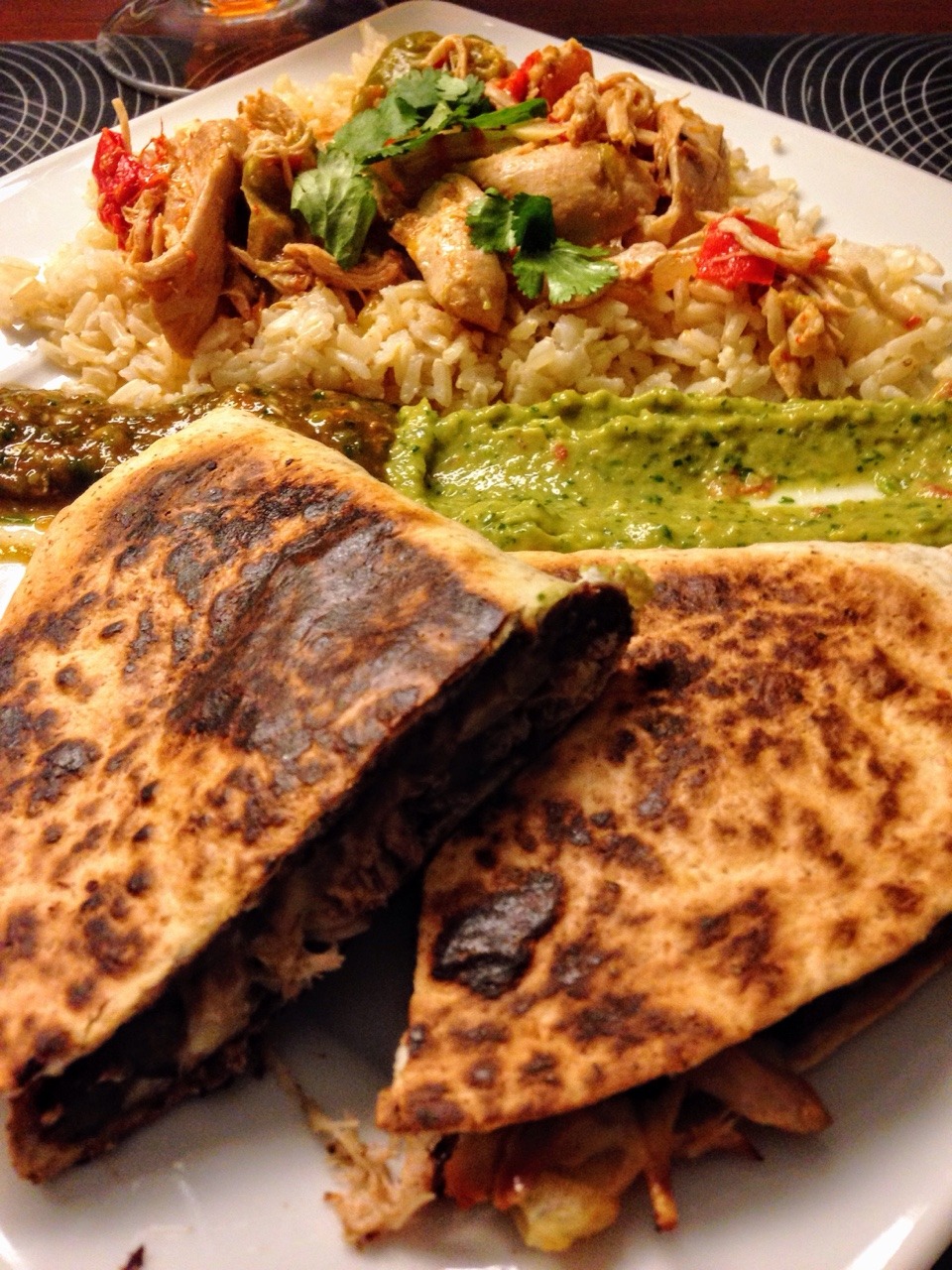 Quesadilla with black beans and cheese, served with brown rice with chicken taco topping, guacamole and jalapeño salsa