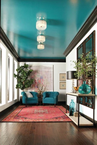 White walls accented with striking black moulding, and a glossy turquoise ceiling