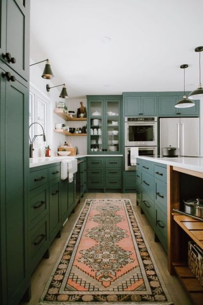 Green kitchen with vibrant pink rug.