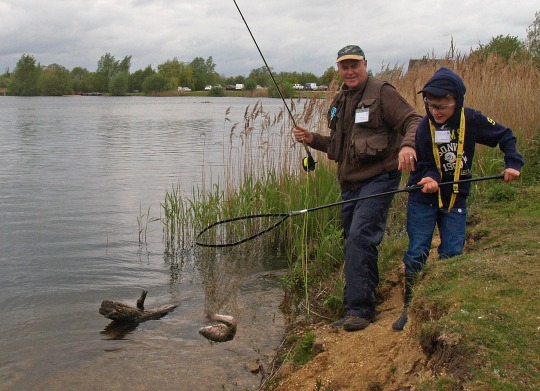 fly fishing boy catching trout with net