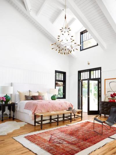 Light-filled bedroom features a high, vaulted ceiling and bold, black-framed windows to contrast with the white walls and ceiling in this home in Southern California. [966 × 1288]