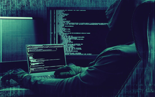 man with hoodie typing computer dark web codes in the laptop 