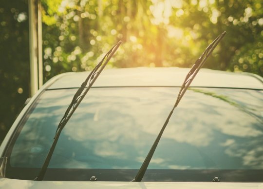 limpadores para brisa erguidos em um carro há muito tempo parado na garagem