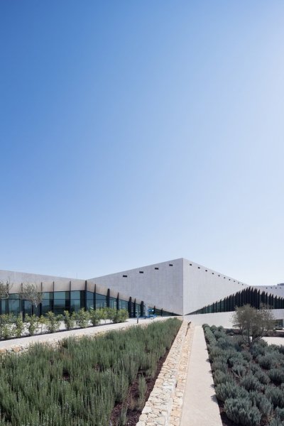 archatlas:<br />Palestinian Museum in Birzeit<br />The landscape of the Palestinian Museum by Heneghan Peng has the ‘worked’ quality of a city; every element of it has been touched and tells a story of intervention, production, culture, environment, commerce. Like a city, the terraced landscape has embedded within it its history. The approach to the Palestinian Museum is to draw on this history of the terraced landscape, embedding the museum into its immediate site and drawing from this site to tell a larger story of a diverse culture.<br />The cascade of terraces tells a diversity of stories, citrus brought in through trade routes, native aromatic herbs, a rich and varied landscape with connections east and west. The building itself emerges from the landscape to create a strong profile for the hilltop both integrated into the landscape yet creating an assertive form that has a distinctive identity.<br /><br /><br />Follow the Source Link for images sources and more information. <br /><br /><br />