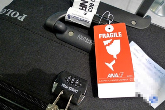 orange fragile label tie into the suitcase