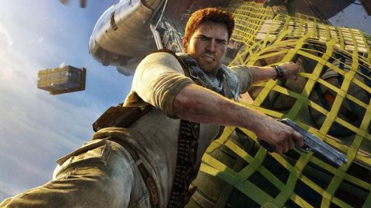Nathan Drake hangs on to a plane cargo strap for his dear life in a promo shot from Uncharted
