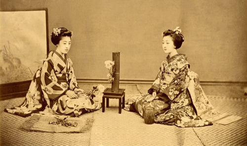 Arranging Flowers 1880s (by Blue Ruin1)
“ Two Maiko (Apprentice Geisha) seated next to an Ikebana flower arrangement. The senior Maiko on the left holds Ikebana scissors in her hand, while the junior Maiko on the right holds a folding fan.
”