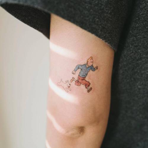 Tintin and Milou on the run tattoo on the back of the left arm.... small;cartoon character;the adventures of tintin;tintin;fictional character;tricep;tiny;cartoon;little;soltattoo;film and book