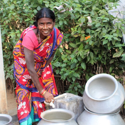 woman opening water tap at home in Indian village