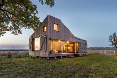 archatlas:<br /><br />Zilvar House ASGK Design<br /><br /><br /><br /><br />The experimental low-energy wooden house Zilvar won honorable mention the Architecture Grand Prix in 2014 in the Family House category. The land is located in the outskirts of a small quiet village surrounded by fields, meadows and woods and is the ideal place for peace and relaxation. The investor decided to construct a weekend house which is designed as one living space with two galleries which provides maximum communication with the garden. Its unconventional shape opens up views of the old oak tree and pond, and across the terrace to the garden’s central section.<br />Images and text via ASGK Design<br /><br /><br />