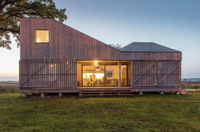 archatlas:<br /><br />Zilvar House ASGK Design<br /><br /><br /><br /><br />The experimental low-energy wooden house Zilvar won honorable mention the Architecture Grand Prix in 2014 in the Family House category. The land is located in the outskirts of a small quiet village surrounded by fields, meadows and woods and is the ideal place for peace and relaxation. The investor decided to construct a weekend house which is designed as one living space with two galleries which provides maximum communication with the garden. Its unconventional shape opens up views of the old oak tree and pond, and across the terrace to the garden’s central section.<br />Images and text via ASGK Design<br /><br /><br />