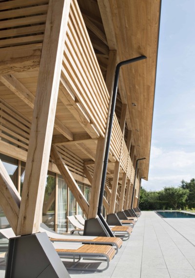 archatlas:<br /><br /><br />Hôtel des Berges’ Spa des Saules in Illhaeusern<br /><br /><br />Conceived as a contemporary reinterpretation of an Alsatian farm by the agency <br /><br />Jouin Manku, the Hôtel des Berges’ Spa des Saules <br /><br /> of 800m² reflects in its design the timber frames of the region’s large old barns, built with untreated materials the structure is built out of solid timber structure with a dark gray tiled roof, set in a concrete volume and further solidified into the ground through a smooth stone base.<br /><br /><br />Follow the Source Link for image sources and more information. <br /><br /><br />