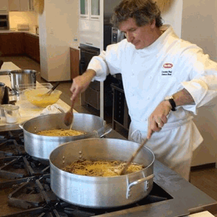 GIF of a chef stirring two massive pots of pasta