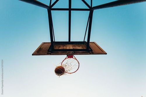 Basketball Scoring a Goal Through the Net, Blue Sky in...