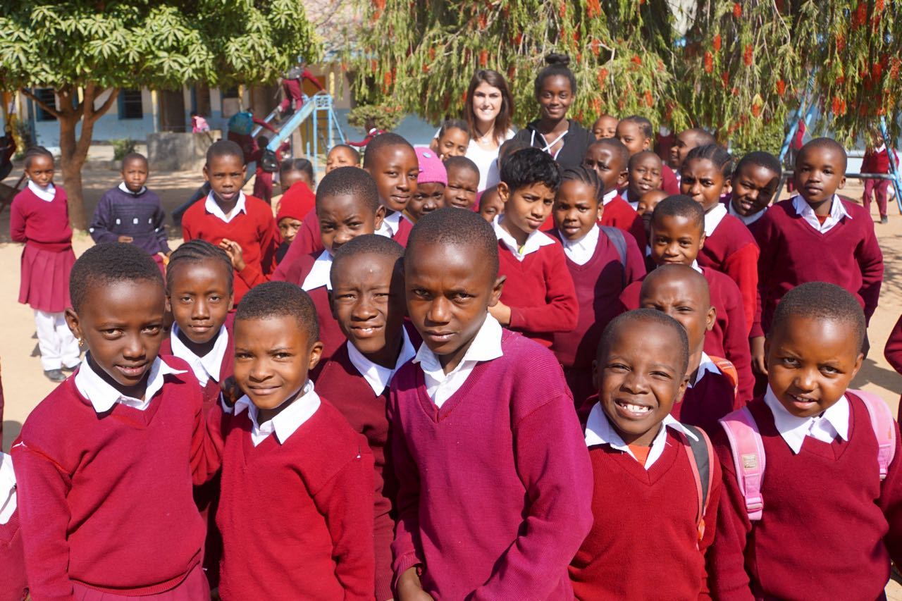 The Other Africa — Maya walks into the school yard to a chorus of...