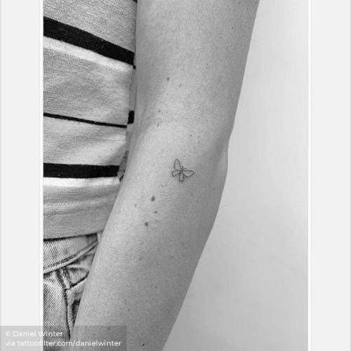 Fine line butterfly tattoo on the bicep