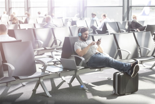 passenger wearing headphone in the airport waiting area