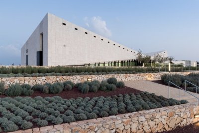 archatlas:<br />Palestinian Museum in Birzeit<br />The landscape of the Palestinian Museum by Heneghan Peng has the ‘worked’ quality of a city; every element of it has been touched and tells a story of intervention, production, culture, environment, commerce. Like a city, the terraced landscape has embedded within it its history. The approach to the Palestinian Museum is to draw on this history of the terraced landscape, embedding the museum into its immediate site and drawing from this site to tell a larger story of a diverse culture.<br />The cascade of terraces tells a diversity of stories, citrus brought in through trade routes, native aromatic herbs, a rich and varied landscape with connections east and west. The building itself emerges from the landscape to create a strong profile for the hilltop both integrated into the landscape yet creating an assertive form that has a distinctive identity.<br /><br /><br />Follow the Source Link for images sources and more information. <br /><br /><br />