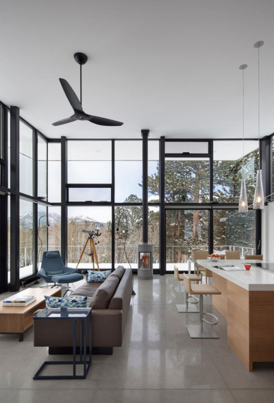 Living and eating area features double-height glass walls to maximize the view in this home located in the Rocky Mountains of Colorado. [1200 × 1763]