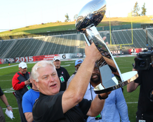 Mike Martz, Coach of the NFLPA Nationals team, holding up the NFLPA Collegiate Bowl Trophy in triumph
