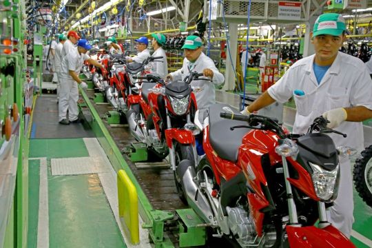 linha de produção de motos honda com funcionários uniformizados e motocicletas vermelhas