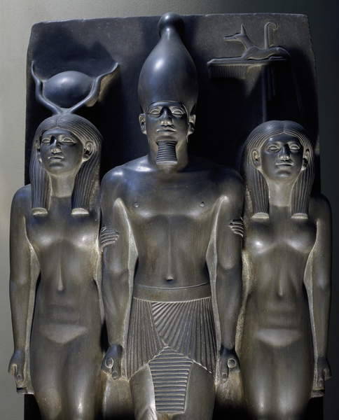 Triad of MenkaureThe king accompanied by Hathor and a Nome Goddess with the crouching jackal emblem of the nome of Cynopolis. Menkaure is wearing the white crown of Upper Egypt, the schist statue is from the Valley Temple of the Pyramid of Menkaure...