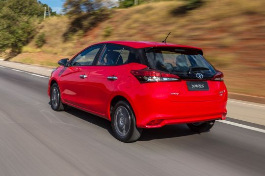 Toyota Yaris vermelho em movimento na estrada