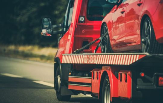 Caminhão rebocando o carro do motorista que estragou na rodovia