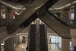 Le 30 mars 2020, des membres du personnel se tiennent devant un magasin Dior sur la place internationale de Wuhan.