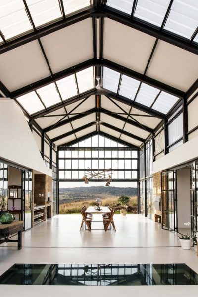 Open air dining area features polished concrete floors and high vaulted ceilings in this home outside of Pretoria, South Africa. [852 x 1277]