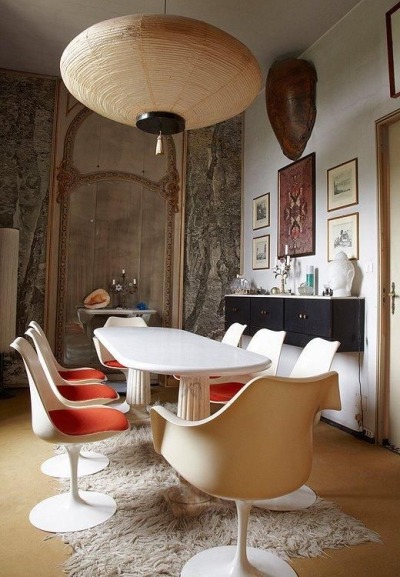 The dining room of Carlo Mollino’s apartment. Classic midcentury EUropean design, blending futuristic molded white tulip dining chairs with baroque gilding and millwork, classical art and neutral colors. Love this midcentury European dining room!